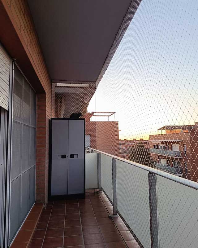 Niño jugando seguro cerca de ventana con malla de seguridad en departamento de Santiago